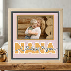 Framed photo of a woman holding a child with 'Nana I love you' text on a pink background.